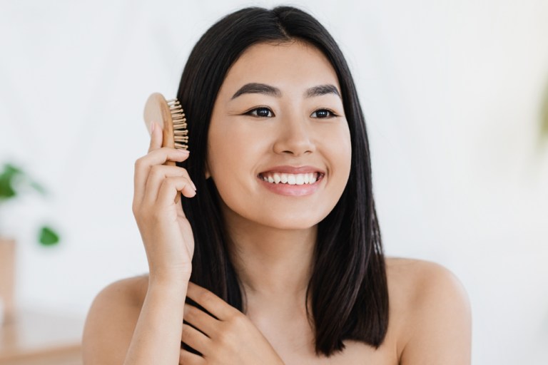 Asian American woman brushing hair